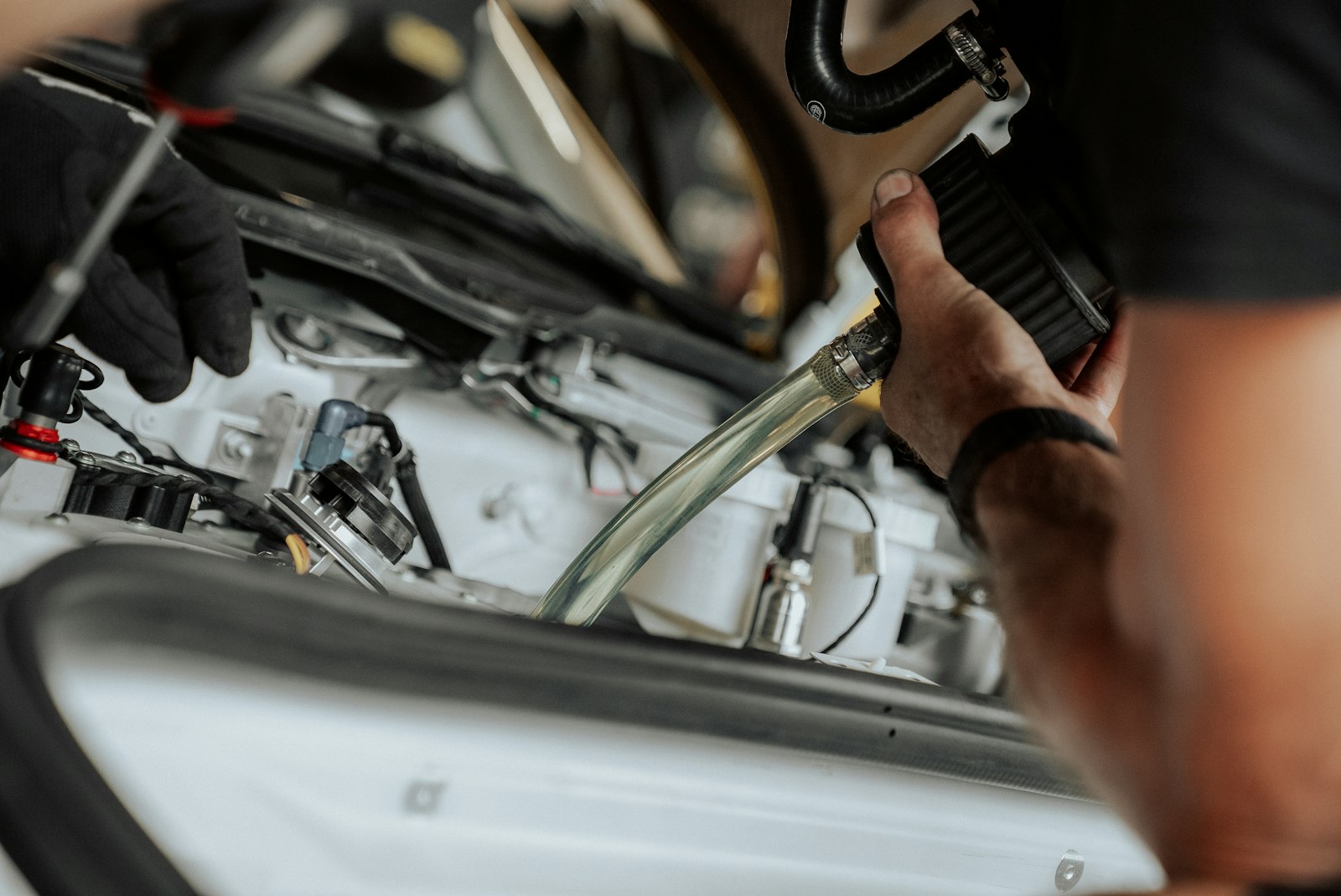 Technicien intervenant sur le compartiment moteur d'une voiture