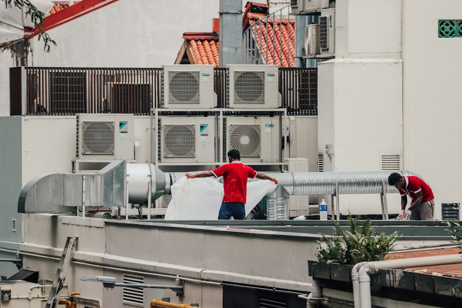 Techniciens inspectant des groupes de climatisation sur un toit