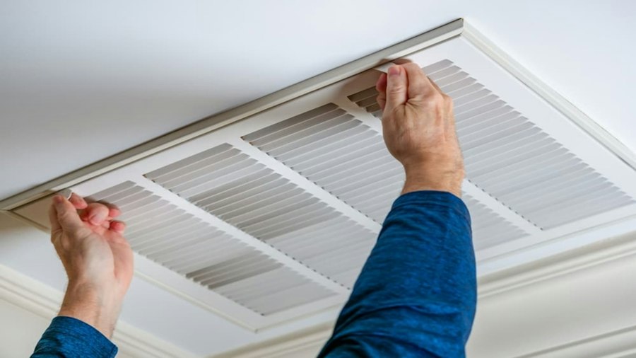 Technicien intervenant sur une climatisation au plafond